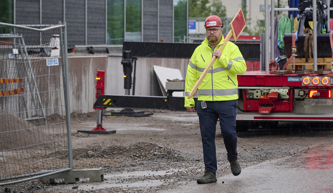 Man från Byggnads går med en röd skylt som kännetecknar indrivningsblockad.