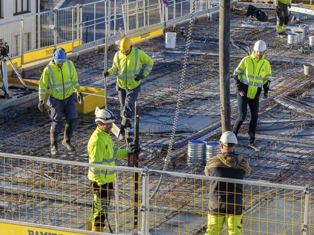 En grupp byggnadsarbetare på ett tak.