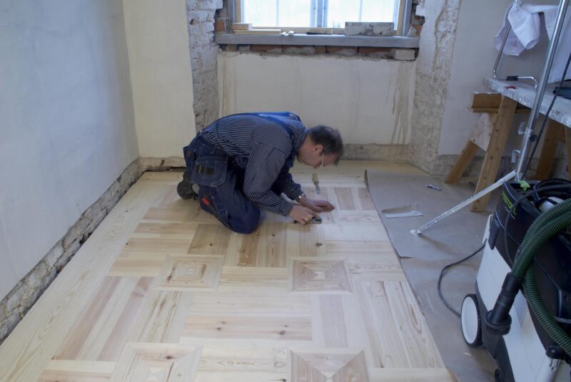 En golvläggare jobbar med renoveringen av Mälsåkers slott.