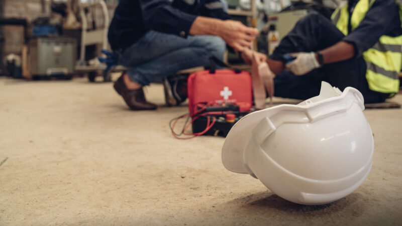 Genrebild på skadad arbetare som får första hjälpen.