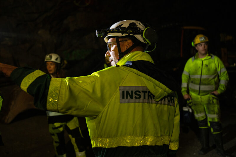 Urban Westermark, iklädd varselkläder med texten instruktör, pekar i förgrunden.